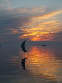 Silhouette duck on lake against sky during sunset