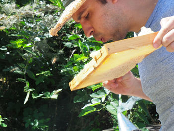 Side view of man holding plant