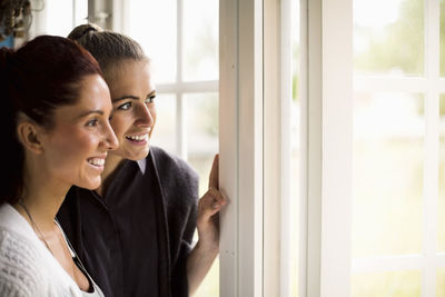 Women looking out through window of summer house