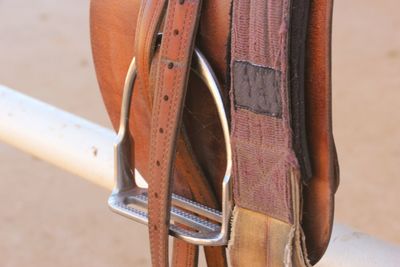 High angle view of saddle on white metallic railing at ranch