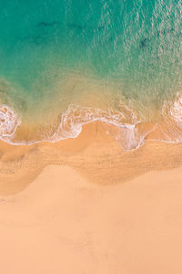 Aerial view of atlantic ocean coast with crystal clear turquoise water, waves rolling into the shore