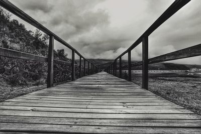 Surface level of footbridge against sky