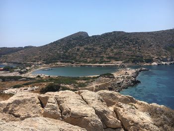 Scenic view of sea and mountains against clear sky