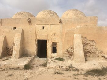 Old ruins of building against cloudy sky