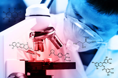 Digital composite image of scientist doing experiment with chemistry formulas