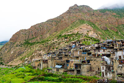 Buildings against mountain range against clear sky