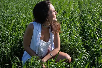 Young woman sitting on grassy field