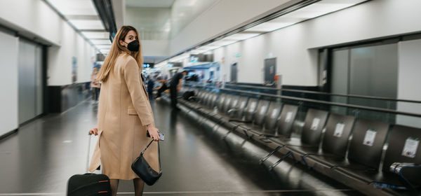 Rear view of woman standing in subway