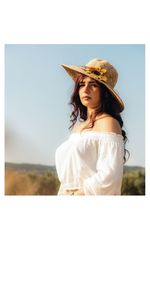 Young woman wearing hat standing against sky