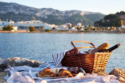 Close-up of food in basket by lake