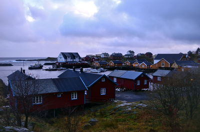 Houses by sea against sky