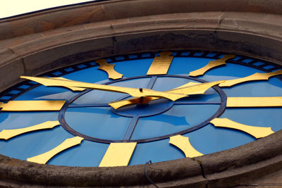 Low angle view of yellow wheel against blue sky