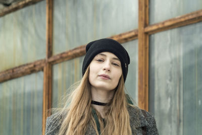 Portrait of teenage girl standing against wall