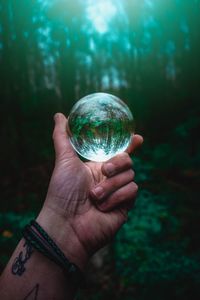 Close-up of hand holding crystal ball