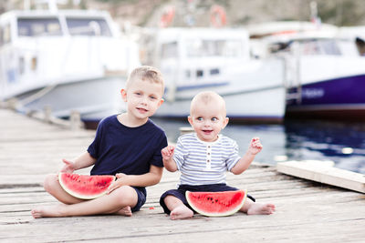 Funny kid boys eating watermelon outdoors. looking at camera. summer time.