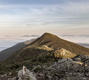 Bigelow mountain, maine, rises above clouds at sunrise