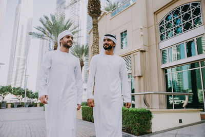 Smiling men in traditional clothing in city