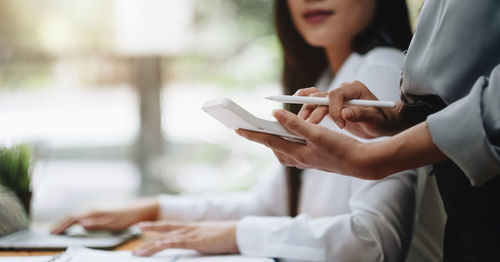 Midsection of woman using mobile phone