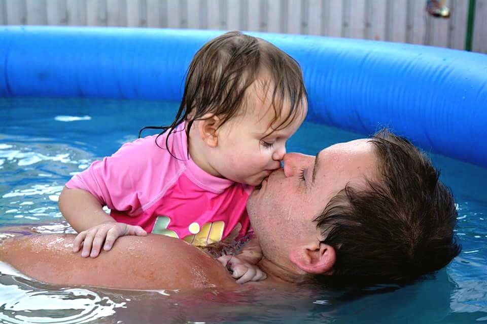 PORTRAIT OF CUTE GIRL LYING IN WATER