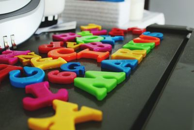 Close-up of colorful magnet alphabets on table
