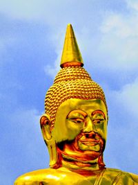 Low angle view of buddha statue against sky