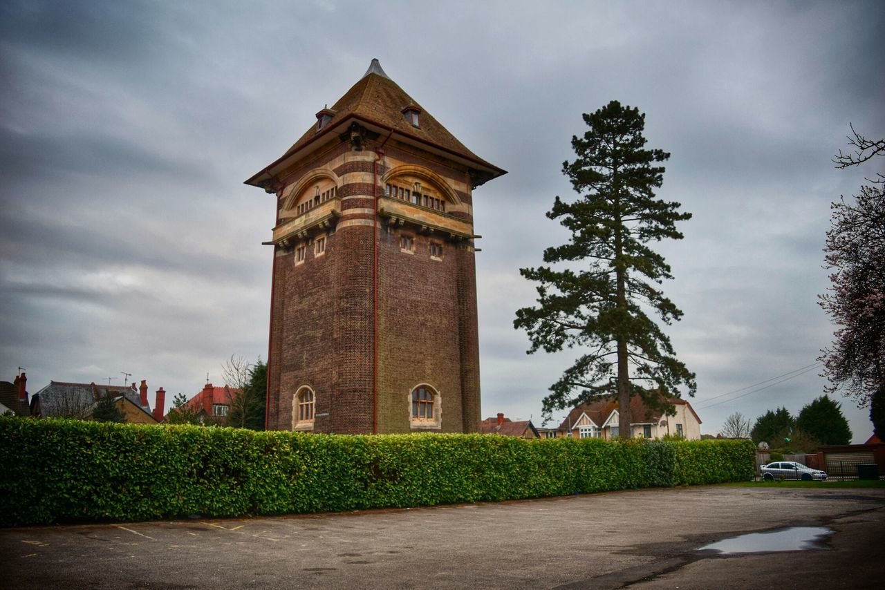 architecture, built structure, sky, building exterior, low angle view, cloud - sky, tree, cloud, cloudy, street, tower, history, road, outdoors, growth, no people, clock tower, transportation, incidental people, car