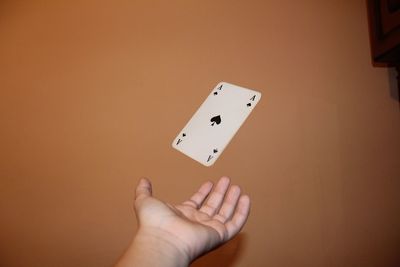 Cropped hand catching card against wall