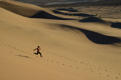Full length of man running on sand