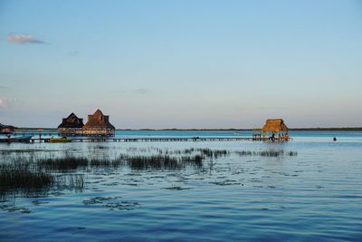 Scenic view of sea against building against clear sky