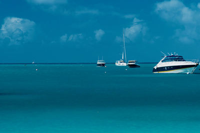 Sailboats in sea against blue sky