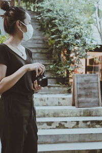 Cinematic style of young women hand holding camera and looking at faraway