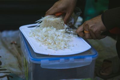 Person cutting enokitake on board