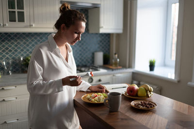 Businesswoman having breakfast at home