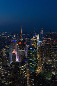 Illuminated cityscape against sky at night