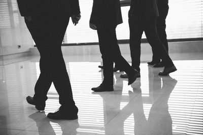 Low section of people walking on floor