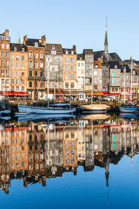 Reflection of buildings in canal against sky