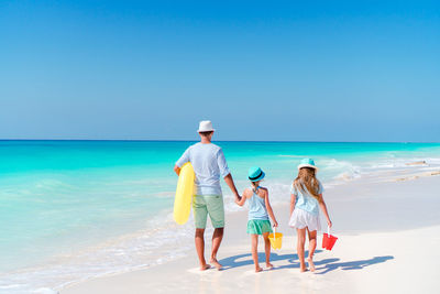 People on beach against blue sky