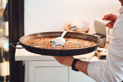 Midsection of man having food in kitchen