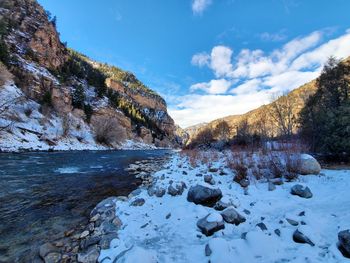 Scenic view of waterfall against sky during winter