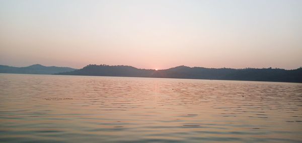 Scenic view of lake against clear sky during sunset