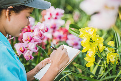 Midsection of woman holding flowering plant