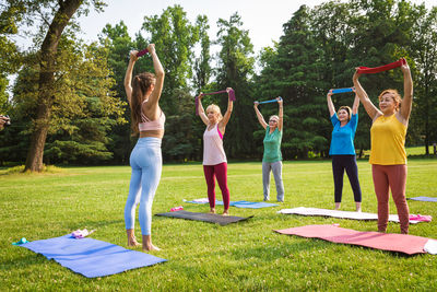 Rear view of woman doing yoga at park