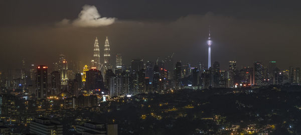 Illuminated city against sky at night