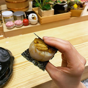 High angle view of man preparing uni sushi on hand
