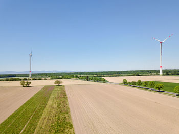 Road amidst field against clear sky