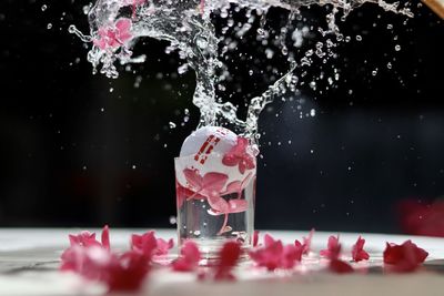 Close-up of pink water splashing on table