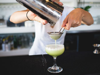 Close-up of hand pouring wine in glass