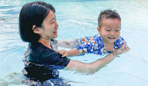 Happy boy smiling in water at shore