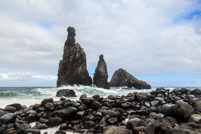 Rocks by sea against sky