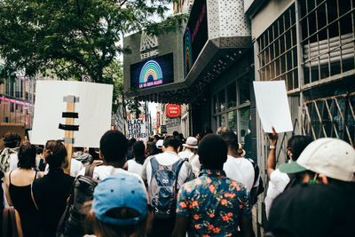 People on street against buildings in city